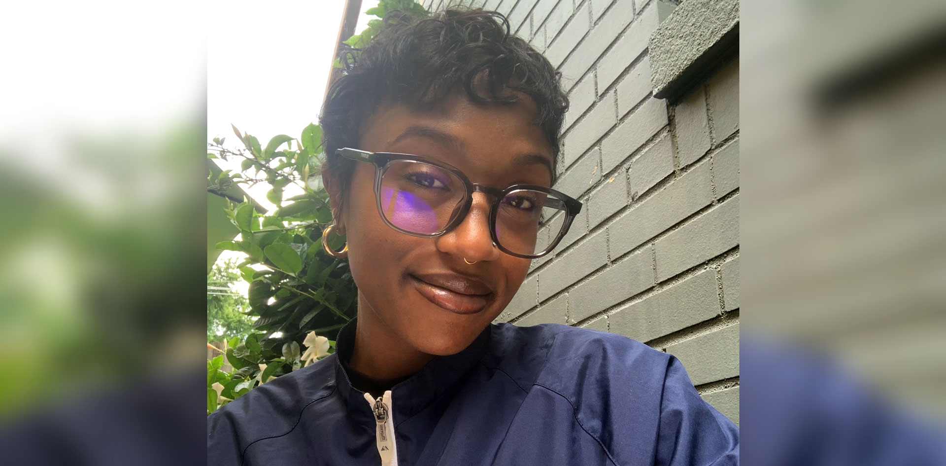 McClay's Logistics accounts payable supervisor, Sydney Eaton sitting outside on a sunny day She's wearing glasses and a navy pullover jacket.